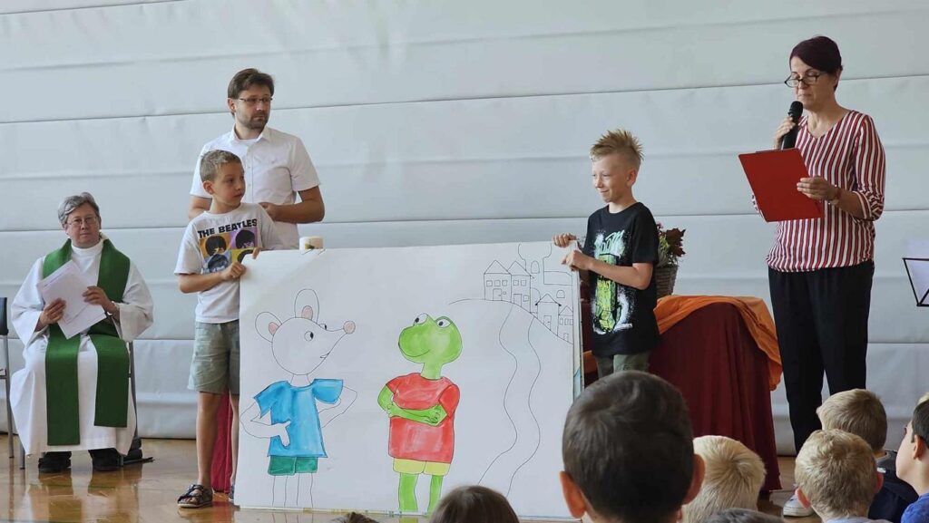 Pfarrer, Pastor, Lehrerinnen und Kinder gestalten gemeinsam einen Gottesdienst